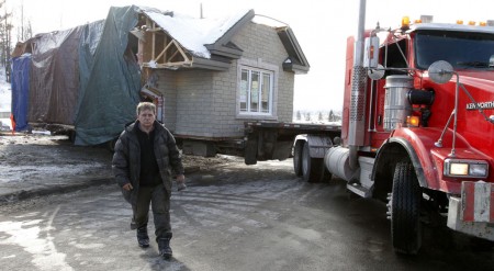 «Lorenzo Guilbeault devant sa maison qui est tirée par un camion lors de son déménagement de la rue Lafrance.»