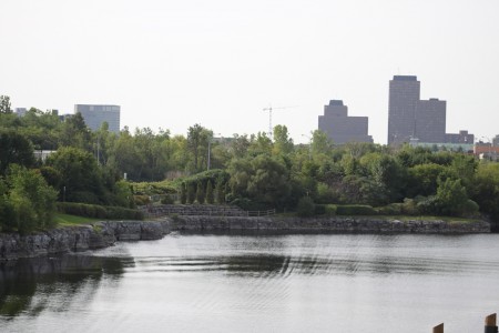 «L’ancienne carrière est aujourd’hui inondée afin de favoriser la villégiature. On voit notamment une piste cyclable en bordure du lac et les édifices du centre-ville à l'arrière-plan.»